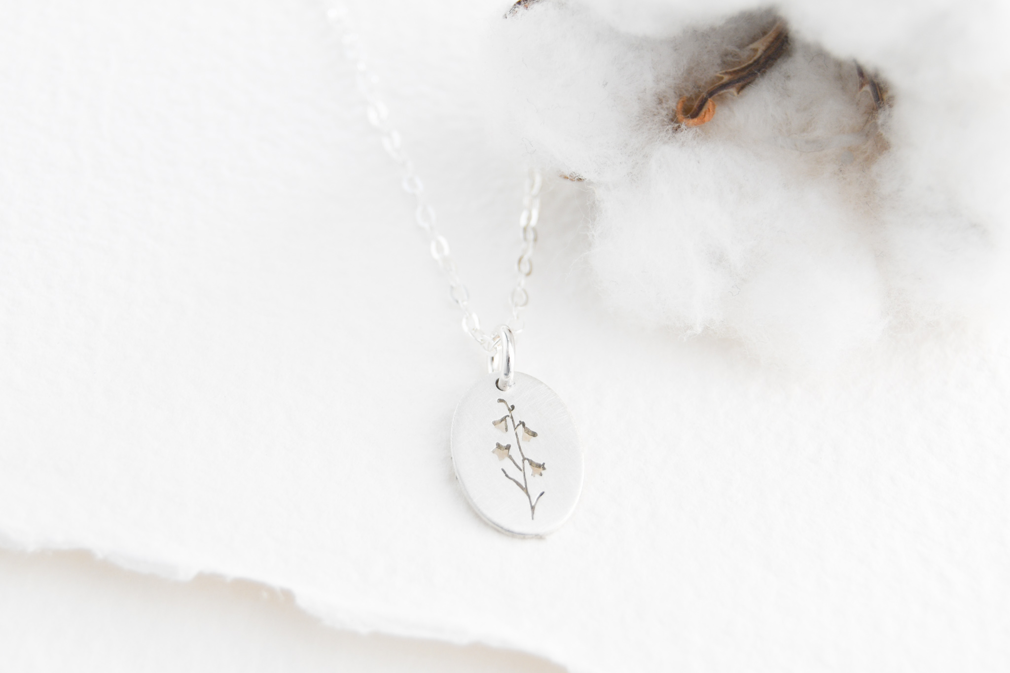 Sterling silver oval pendant with a harebell flower hand cut on the pendant