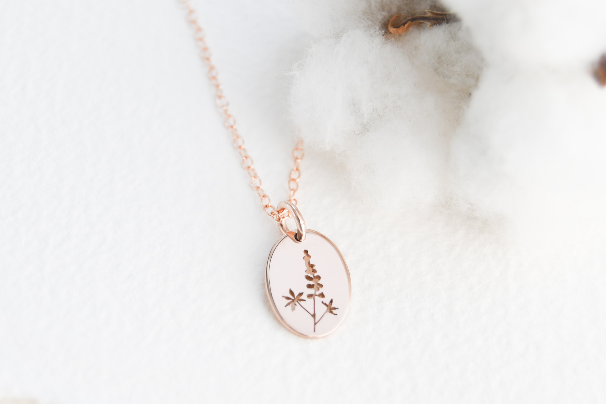 Rose gold filled oval pendant with a hand cut lupin picture on the pendant